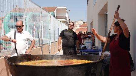El concejal Joaquín Bermejo mira al reloj, mientras la cocinera se afana con la paella
