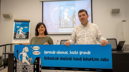 Carol Sáez de Albéniz y Santi Leoné, directora y vicedirector de la Escuela Oficial de Idiomas, muestran un cártel con el lema de este curso. “Aprender idiomas nos ayuda a ampliar nuestros puntos de vista”, dicen.