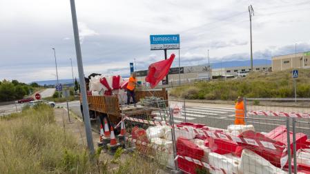 Operarios preparan las balizas para la obra en la rotonda de ‘Covegan’, al fondo de la imagen