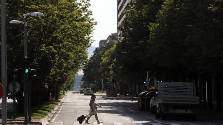 una mujer cruza la avenida de Pío XII