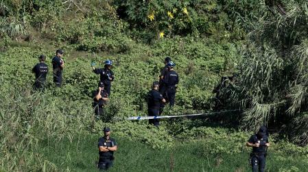 Agentes de la Policía Nacional custodian el lugar donde ha sido hallado el cuerpo sin vida del hombre que fue arrastrado por el agua cuando cruzaba en bicicleta un barranco en Paterna (Valencia)