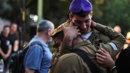 Dos soldados israelíes se abrazan en un funeral en Tel Aviv