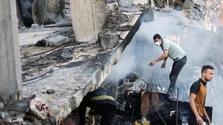Varias personas buscan supervivientes en un edificio destruido en Khan Younis, al sur de Gaza