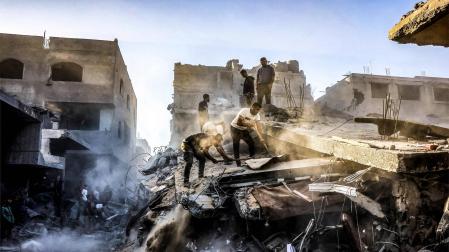 Varios hombres excavan en busca de supervivientes tras un bombardeo israelí sobre Rafah