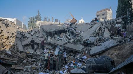 Un grupo de palestinos buscan supervivientes y cadáveres entre los escombros de la iglesia ortodoxa griega de San Porfirio tras un ataque aéreo nocturno de Israel en Gaza