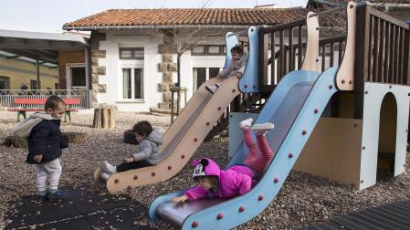 Unos niños juegan en los columpios del patio de recreo de una escuela infantil de Pamplona
