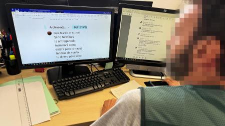 Un agente de la Guardia Civil revisa los mensajes de un caso de estafa del amor