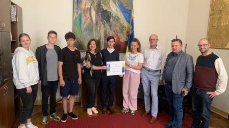 Alumnos, profesora y el director del liceo, a la derecha, reciben el cheque de 5.000 euros de manos de Natalia Dzyudz, del clúster Alas de Ucrania.