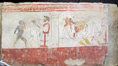 Juegos de gladiadores (a la derecha un combate armado, y a la izquierda un combate de boxeo entre un blanco y un negro al son del aulós) en honor de un difunto. Fresco de tumba lucana en el Museo Arqueológico Nacional de Paestum