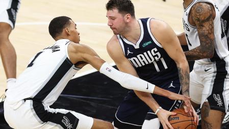 Victor Wembanyama (izda.) y Luka Doncic(dcha.) pelean por el balón durante el encuentro