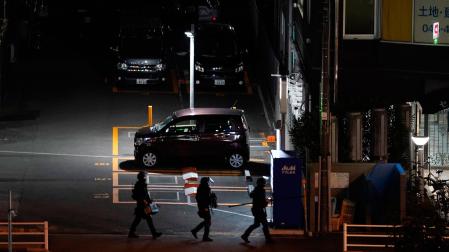 Miembros de la unidad táctica de la policía japonesa caminan cerca de la oficina de correos de Warabi, donde un pistolero tomó rehenes y se atrincheró en la ciudad de Warabi tras un tiroteo en un hospital