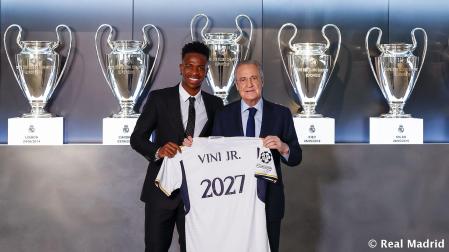 Vinicius Jr. junto a Florentino Pérez posan con una camiseta con el año 2027, fecha hasta la que ha renovado el jugador