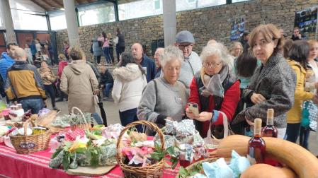 Un grupo de personas se interesan por el contenido de unas cestas, rellenas de productos elaborados con materia prima del campo.