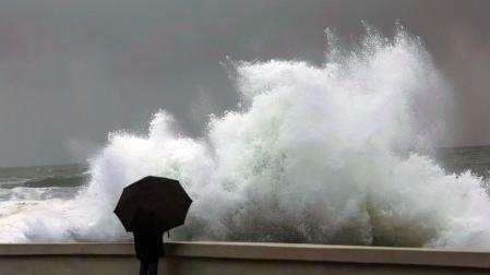 Una persona observa cómo rompe el fuerte oleaje en la costa de Baiona (Pontevedra)