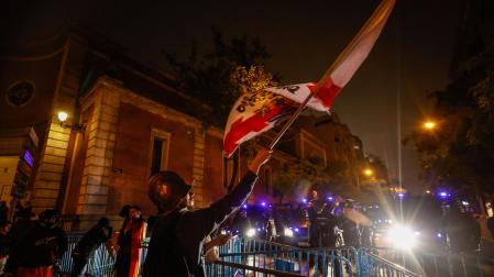 Varias personas portan banderas, durante una protesta en la calle Ferraz, este viernes por la noche
