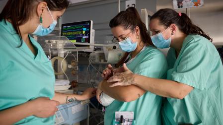 Tres sanitarias atienden a un bebé prematuro en la unidad neonatal del Hospital Universitario de Navarra.