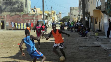 En una calle de Saint Louis, al norte de Senegal, un joven trata de zafarse de su defensor en un improvisado encuentro de fútbol