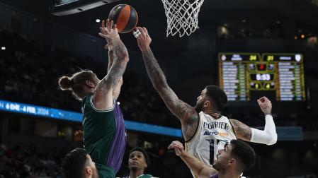 El pívot francés del Real Madrid Vincent Poirier (dcha.) intenta taponar a Dylan Osetkowski (izda.) pívot estadounidense de Unicaja durante el partido