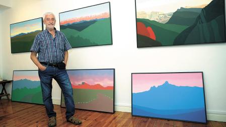 Pedro Salaberri, en su estudio de pintura de Pamplona, junto a algunos paisajes que le caracterizan