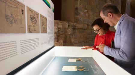 Dos personas atienden uno de los paneles informativos de la muestra./