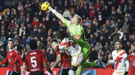 El meta del Celta, Guaita, despeja de puños saltando más que los rivales en una jugada dle partido./