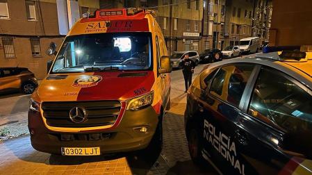 Una ambulancia y un vehículo de la Policía Nacional, en el exterior de la vivienda en la que se produjo la agresión, en el madrileño distrito de San Blas