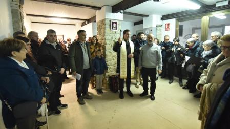 El párroco de Tafalla, Fermín Macías, bendice la exposición en presencia de los belenistas y quienes asistieron a la inauguración