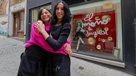 Soraya Echeverría López y Elena Sucunza Monterrubio junto a la peluquería del escaparate ganador./