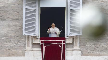 El Papa Francisco lee su mensaje de Navidad asomado al balcón de la fachada de la basílica de San Pedro