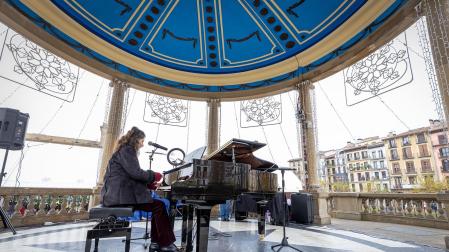Fotos de personas tocando el piano de cola instalado en el kiosco de la Plaza del Castillo de Pamplona. /