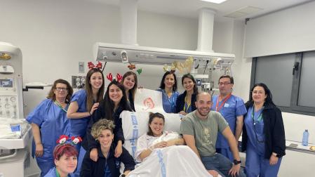 Carla, la primera niña en nacer en España, junto a sus padres y el resto de enfermeras y matronas del Hospital de Salamanca que han intervenido en el parto.