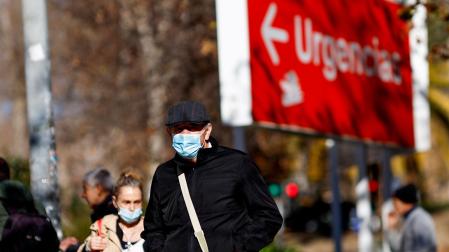 Personas con  mascarillas caminan en el entorno de un centro sanitario en Madrid