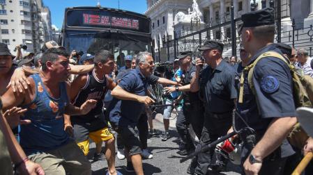 Manifestantes se enfrentan a la policía durante una protesta convocada por la Confederación General del Trabajo hoy, en Buenos Aires