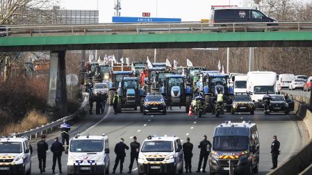 Agentes de policía vigilan decenas de tractores que participan en una manifestación en la autopista A15 cerca de Argenteuil, al norte de París