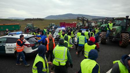 Fotos del momento en el que los agricultores apartan a la fuerza dos coches de la Guardia Civil en la A-12 para seguir hacia Pamplona.