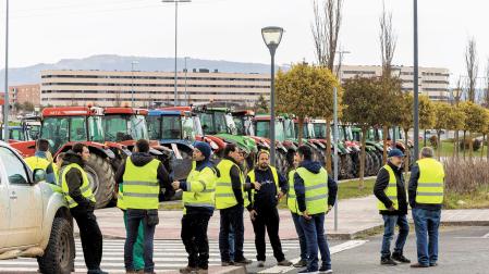 Una quincena de agricultores conversan en Zizur antes de trasladarse al centro de la capital navarra para sumarse a la marcha a pie