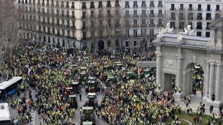 Tractores y manifestantes, este miércoles a su paso por la Puerta de Alcalá, en Madrid