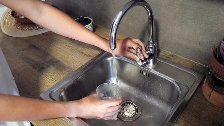 Una persona llena un vaso de agua de grifo en Pamplona