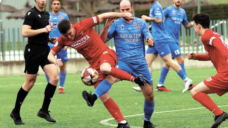 Endika Irigoien, lateral del Izarra, e Imanol Areallano, mediocampista del Valle de Egüés disputan un balón.