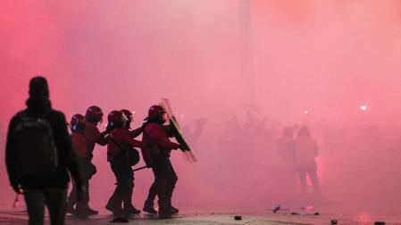 Varios agentes de la Ertzaintza se protegen ante el lanzamiento de objetos en la entrada del estadio San Mamés, momentos antes del partido de vuelta de semifinales de la Copa del Rey