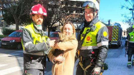 La dueña con el animal en brazos junto a miembros del equipo de rescate que lo encontraron.
