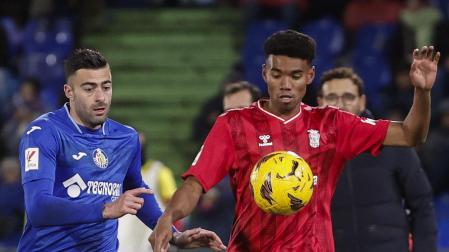 El centrocampista de Las Palmas, Marvin Olawale, intenta controlar el balón ante el defensa del Getafe, Diego Rico