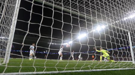 El guardameta de la Real Sociedad, Alex Remiro, intenta detener el remate del delantero del PSG, Kylian Mbappe