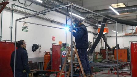 Dos de los trabajadores del Tajo de Soldadura del Ayuntamiento de Pamplona, en plena fabricación de uno de los kioskos de los 'naranjitos'