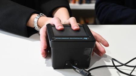 Una voluntaria escanea sus huellas dactilares con una herramienta diseñada con Inteligencia Artificial para predecir la esquizofrenia