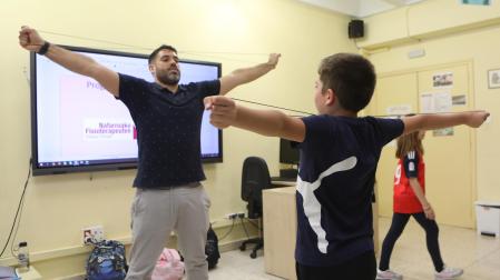 El fisioterapeuta Roberto Martínez practica un ejercicio con un alumno de 4º de Primaria del CP Ermitagaña de Pamplona.