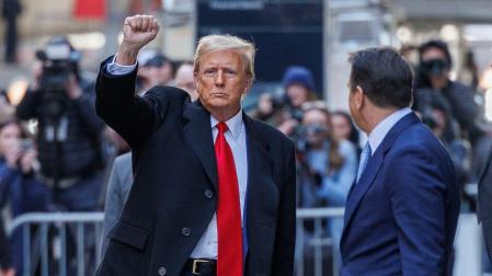 El expresidente de Estados Unidos Donald Trump levanta el puño tras salir de un tribunal de apelaciones de Nueva York que autorizó al magnate a pagar una fianza menor de la establecida en un principio en un caso de fraude civil