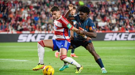 El delantero argentino del Granada Lucas(i) pelea un balón con el defensa portugués del Valencia Thierry Correia (d) durante el partido de LaLiga entre Granada CF y Valencia CF