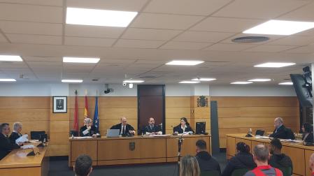 Los tres acusados, delante de la Policía Foral, durante la vista de este martes