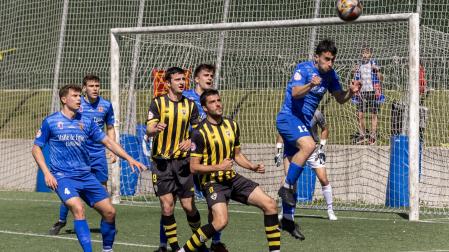 Astráin despeja el balón con la cabeza dentro del área.